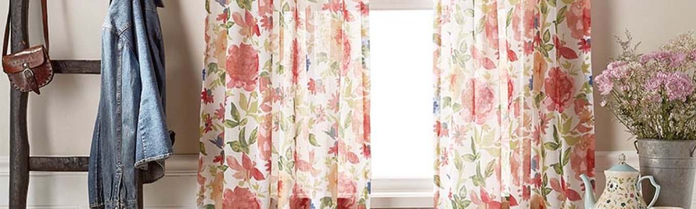 A set of floral curtains in a window. Starts the window treatment ideas blog post on justdealsstore.com.